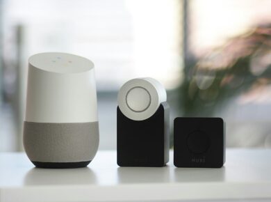 white and gray Google smart speaker and wo black speakers