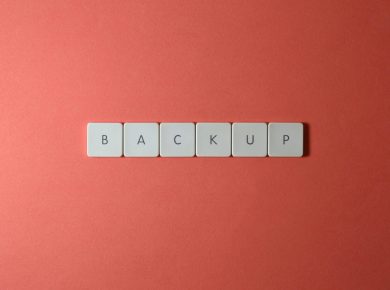 Free Close-up of keyboard keys spelling 'BACKUP' placed on a coral-colored surface. Stock Photo